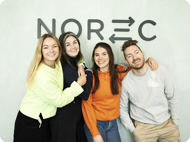 Fire unge arbeidstakere hos Norec ler og smiler mot kamera
