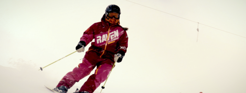 Ung kvinne med skiklede på veg ned ein slalombakke